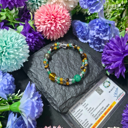 A beaded bracelet containing citrine , green aventurine, clear quartz, pyrite and tiger eye displayed on a dark slate block with certificate surrounded by artificial flowers.