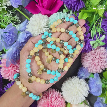 A bracelet for numerology 3 and jupiter containing turquoise, pyrite and yellow calcite with be tru charm with a dark backgroundA bracelet for numerology 3 and jupiter containing turquoise, pyrite and yellow calcite with be tru charm with a dark background